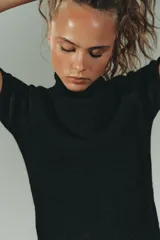 Jersey de punto suave con cuello subido y manga corta, con acabados en vuelta en los bordes.