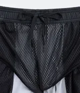 Bermuda deportiva de poliéster con estampado camuflado en tonos grises y blancos, cintura elástica con cordón ajustable y bolsillos laterales con cierre.