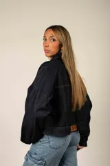 Campera corta de denim con estampado camuflado en tonos de azul, cierre frontal completo y bolsillos en el pecho.
