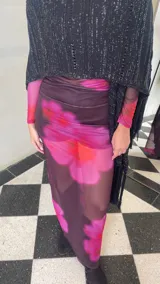 Ruana tejida de color negro con sutiles destellos plateados, diseño de líneas verticales y terminación con flecos largos en los extremos.