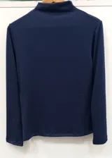 Polera de lanilla color azul marino, de corte ajustado, cuello alto y manga larga.