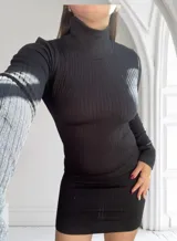 Minivestido negro de punto canalé, con cuello alto y mangas largas.