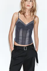 Pantalón cargo de tiro medio confeccionado en tejido satinado. Presenta bolsillos laterales con solapa, corte recto y holgado, y un cinturón integrado del mismo tejido con hebilla metálica.