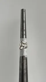 Anillo de plata con diseño orgánico y abstracto que simula pliegues de papel.