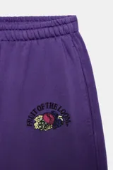 Pantalón jogger morado con efecto lavado de tiro medio y cintura elástica. Presenta bolsillos laterales ocultos, bajo con puño elástico y detalle de logo bordado de Fruit of the Loom en la cadera.