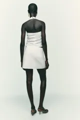 Falda pantalón negra de tiro alto con diseño cruzado y pliegues drapeados en el frente.