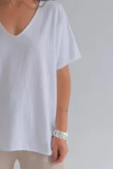Remera blanca de corte holgado con escote en V y mangas cortas.