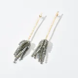 Aros colgantes con base dorada y flecos de cuentas grises.