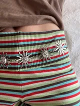 Cadena plateada para la cintura con dijes de soles sonrientes.