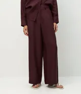 Pantalón de corte recto confeccionado en lino, con cintura elástica y trabillas para cinturón. Presenta un diseño fluido y elegante, ideal para un look sofisticado y cómodo.