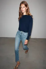 Jeans mom fit de tiro alto color negro con efecto lavado, diseño de cinco bolsillos y corte tobillero.