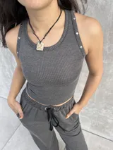 Top musculosa negro de morley elastizado con textura rib bicolor de líneas finas. Presenta detalle de tachas metálicas en los hombros.