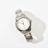Reloj Q&Q plateado con malla de acero quirúrgico, esfera blanca con números arábigos y agujas luminiscentes.