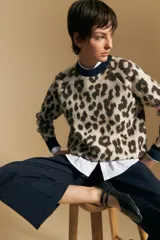 Sweater de tejido jacquard con estampado animal print, de silueta relajada y manga larga. Presenta cuello redondo y bordes en contraste de color bordó.