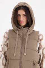 Chaleco largo acolchado con capucha ajustable, cierre frontal y bolsillos laterales con cierre.