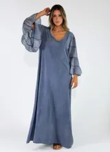 Vestido largo color azul, con escote en V, mangas largas amplias con volados escalonados y diseño holgado.