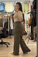 Pantalon sastrero de corte recto y tiro alto, color marrón con diseño de rayas verticales finas. Cuenta con cierre frontal con botón y bolsillos laterales.