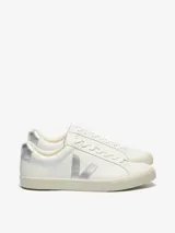 Championes Veja modelo Esplar, de diseño minimalista en color blanco con detalles metalizados plateados en el logo lateral y el talón. Presentan cierre de cordones y suela de goma en tono crema.