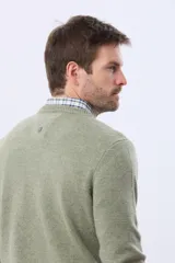 Buzo tejido de lana con escote redondo a la base, de manga larga y calce clásico.