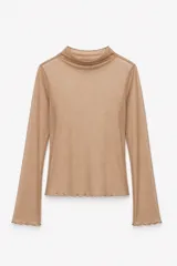 Blusa de tul color marrón, con cuello alto, mangas largas y terminaciones con borde ondulado.