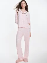 Camisa de pijama de manga larga con cuello solapa y cierre frontal de botones. Presenta un estampado sutil de pequeños corazones sobre una base de color gris melange, con detalles de ribete en contraste en el cuello y la botonera.