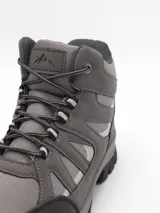Bota de trekking color negro, con diseño de caña media, confeccionada en materiales sintéticos resistentes y malla transpirable. Cuenta con suela de goma dentada para mayor tracción y cordones reforzados.