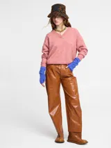 Sweater de punto color rosado, con cuello polo y escote en V. Tiene manga larga con puños ajustados y ruedo en punto ajustado.