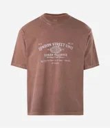 Remera masculina color marrón con efecto desgastado, de corte boxy y mangas cortas. Presenta un estampado frontal en blanco con el texto "London Street Unit" y un globo terráqueo.