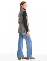 Chaleco gris de diseño híbrido, con frente capitoneado de patrón ondulado y espalda de tejido de punto. Presenta cuello con solapa, cierre frontal con botones a presión metálicos, cordón de ajuste en la cintura y bajo curvo.