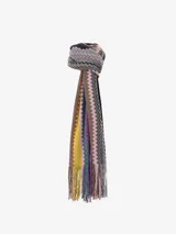 Chal tipo bufanda de punto con diseño de zigzag multicolor, característico de Missoni. Presenta un borde rojo sólido y flecos en los extremos.