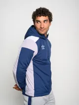 Campera deportiva Umbro con capucha, cierre frontal y bloques de color. El cuerpo principal es azul marino, los hombros son blancos y las mangas tienen paneles laterales en gris claro.