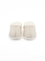 Pantuflas tipo zueco en color beige con diseño de espiga y borde de piel sintética en color crema.