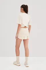 Falda de tennis negra con volados y short interno, confeccionada en tejido de alta torsión.
