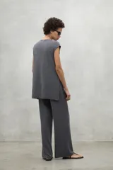 Chaleco de punto en lino color gris, con cuello en V, corte holgado y aberturas laterales en el ruedo.