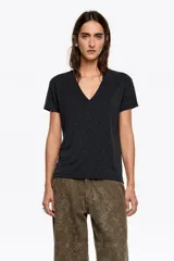 Camiseta negra de corte recto con escote en pico y manga corta. Presenta una sutil aplicación de pequeñas piedras brillantes distribuidas por toda la prenda.