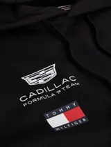Buzo con capucha y cordón ajustable, confeccionado en algodón. Presenta un diseño de corte regular con bolsillo tipo canguro, puños y bajo de punto canalé. Incluye logos de la colaboración Cadillac Formula 1 Team y Tommy Hilfiger en el pecho, además de detalles distintivos en la manga y la nuca.