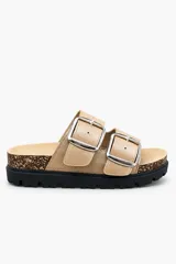 Sandalia tipo birkenstock con plataforma, color beige, con dos tiras anchas ajustables mediante hebillas metálicas plateadas. Cuenta con base de corcho y suela dentada negra.