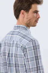 Camisa de manga larga de calce slim, con diseño a cuadros en tonos azul oscuro, verde y blanco. Presenta cuello camisero con botones y bolsillo ojal en el pecho con detalle bordado.