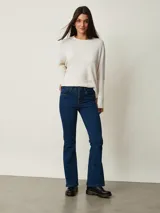 Pantalón de jean negro de corte flare, con tiro medio y bolsillos delanteros y traseros.