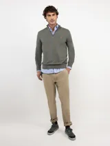 Sweater de punto color verde militar con cuello alto y medio cierre frontal de cremallera, manga larga y detalles acanalados en los puños y el dobladillo.
