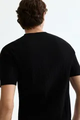 Remera de punto acanalado fino color negro, con cuello redondo y mangas cortas, de corte slim fit.