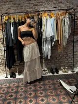 Pollera larga de algodón color beige, con diseño de capas escalonadas y cintura elástica.