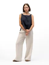 Pantalón de lino beige de corte holgado, con cintura elástica, dos bolsillos laterales y un bolsillo trasero.