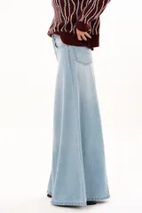 Jean de tiro alto con diseño de pierna extra ancha y caída fluida. Cuenta con bolsillos delanteros y traseros, cierre frontal con cremallera y botón metálico.