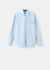 Camisa celeste de algodón y lyocell, con cuello camisero, mangas largas con puños anchos, cierre frontal con botones y sutil bordado floral en el pecho.
