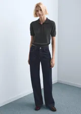 Jeans de tiro medio con diseño de corte recto y holgado, confeccionados en denim azul oscuro con costuras en contraste.