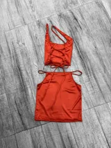 Top negro asimétrico con un solo tirante ancho y un corte en el pecho.