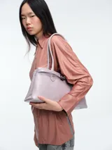 Camisa de corte oversize confeccionada en tejido jersey con acabado brillante. Presenta cuello en punta, cierre frontal con botones, mangas largas con puños anchos y tajos laterales en el ruedo.