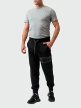 Pantalón de jogging negro de algodón con cintura elástica ajustable con cordón, bolsillos laterales y banda horizontal con logo de la marca en el muslo izquierdo.