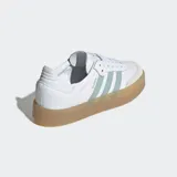 Championes Adidas Sambae blancos con las tres rayas laterales en verde agua y suela de goma color caramelo.